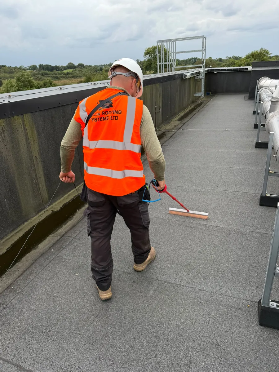 Govin Roofing technician carrying out an electronic leak detection sweep on a flat roof
